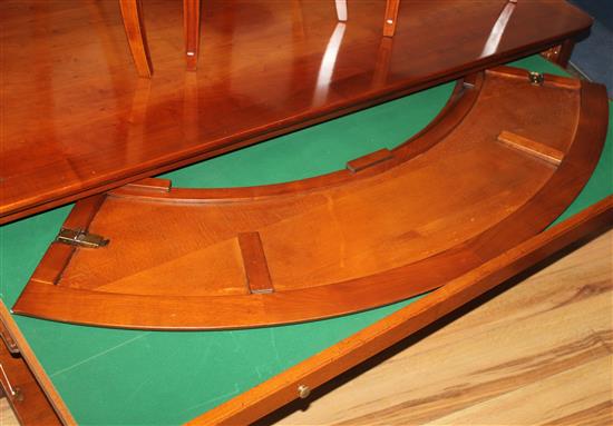 A 20th century French cherrywood radially extending dining table, the circular table extends to 6ft 7in.